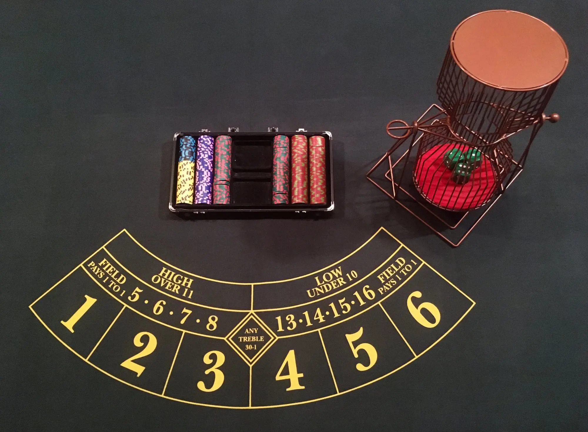 Le tapis de Chuck a Luck du kit, avec la cage à dés et la mallette de jetons